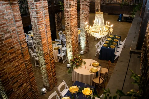 event tables and chairs with the walls and columns covered in old bricks