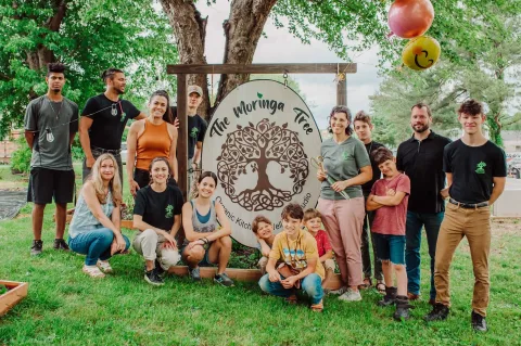 The Moringa Tree Cafe staff standing in front of their sign