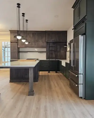 Country-style kitchen with dark green cabinets and open wall island