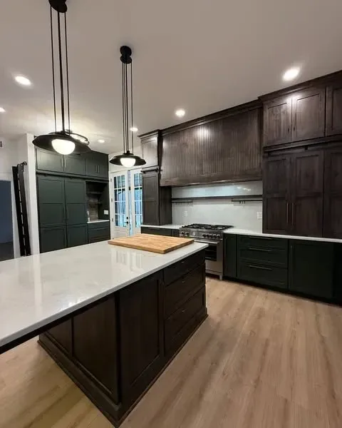 Two-tone olive green and dark wood kitchen with waterfall island