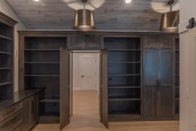 Large dark wood office with shelves and cabinets from floor to ceiling