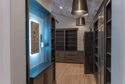 Large office with custom dark wood shelves and blue accent lights