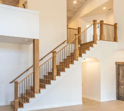 Large open floorplan with white walls and brown open staircase